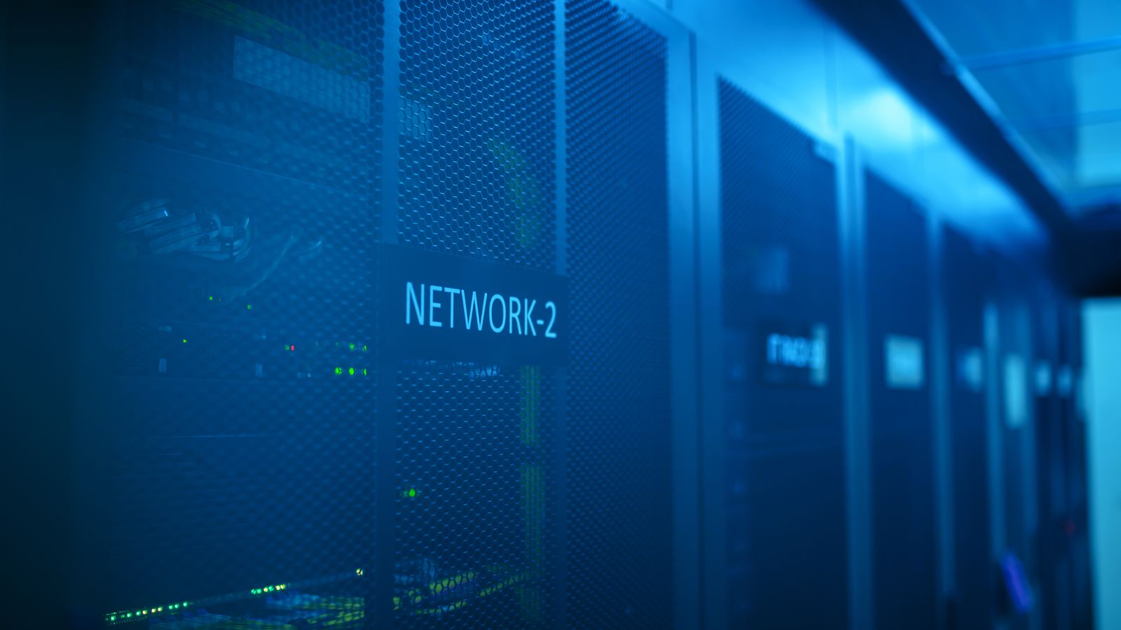Blue-lit network equipment rack with status lights and a Network 2 label